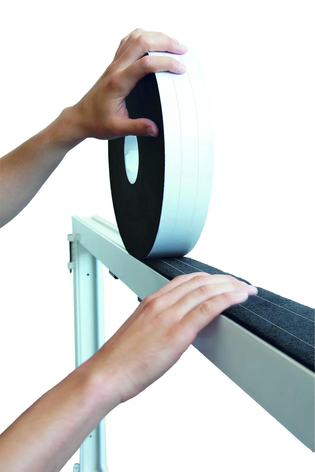 Deux mains posant une bande d&rsquo;&eacute;tanch&eacute;it&eacute; en mousse noire ISO-BLOCO HYBRATEC sur un profil&eacute;