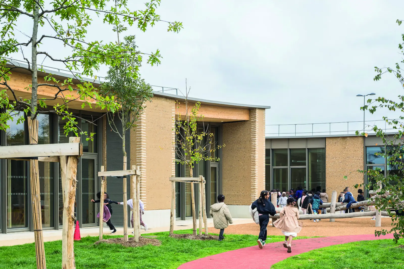 Enfants courant dans le jardin plant&eacute; devant les b&acirc;timents