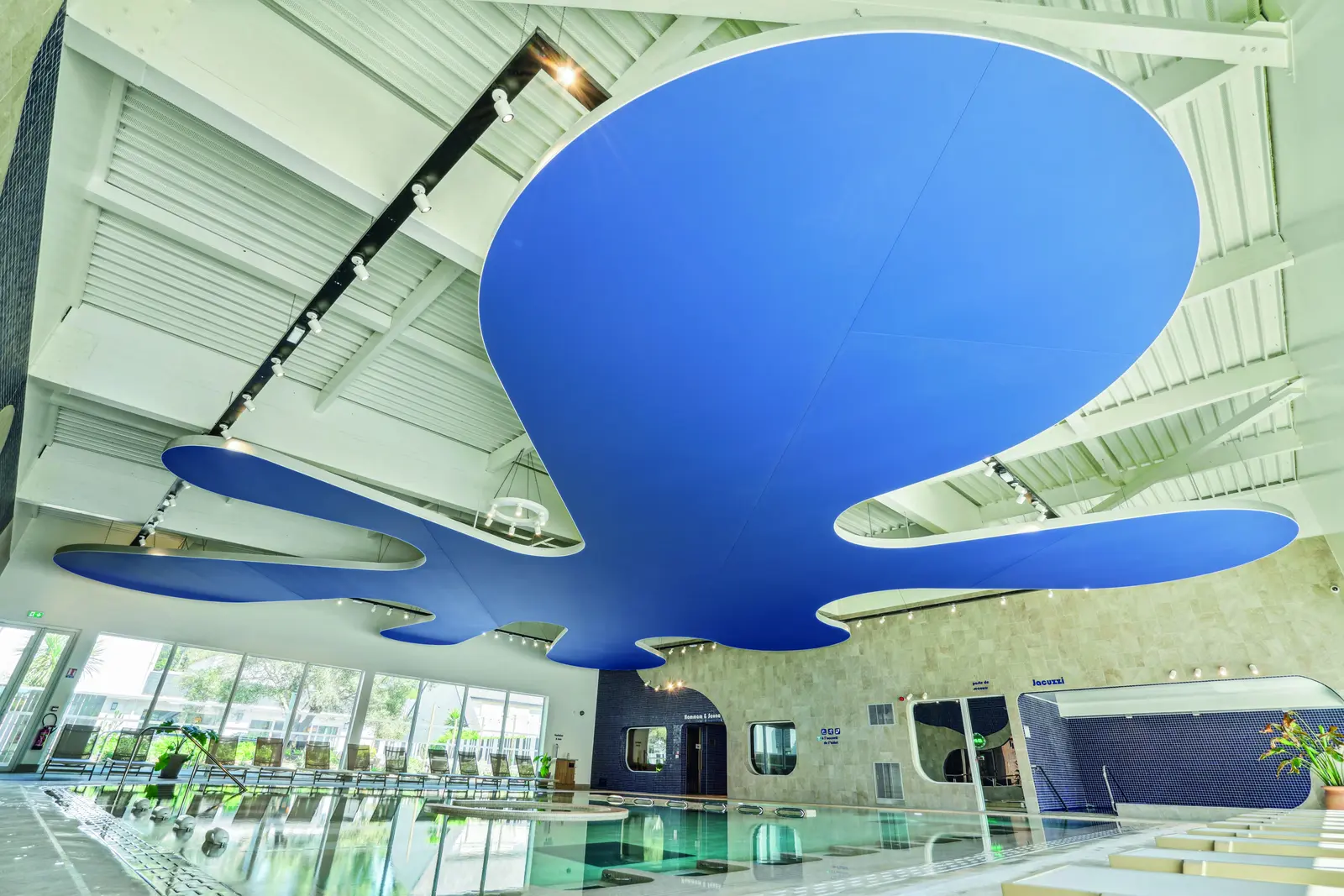 Plafond suspendu bleu aux formes organiques au-dessus du bassin