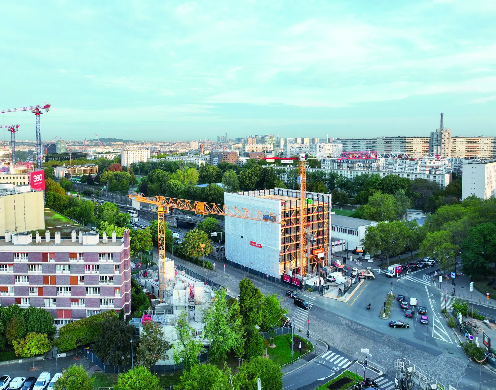 Vue a&eacute;rienne du chantier de l&rsquo;immeuble Hosta, &eacute;chafaud&eacute;, avec une grue, &agrave; la porte de Brancion, la tour Eiffel &agrave; l&rsquo;horizon