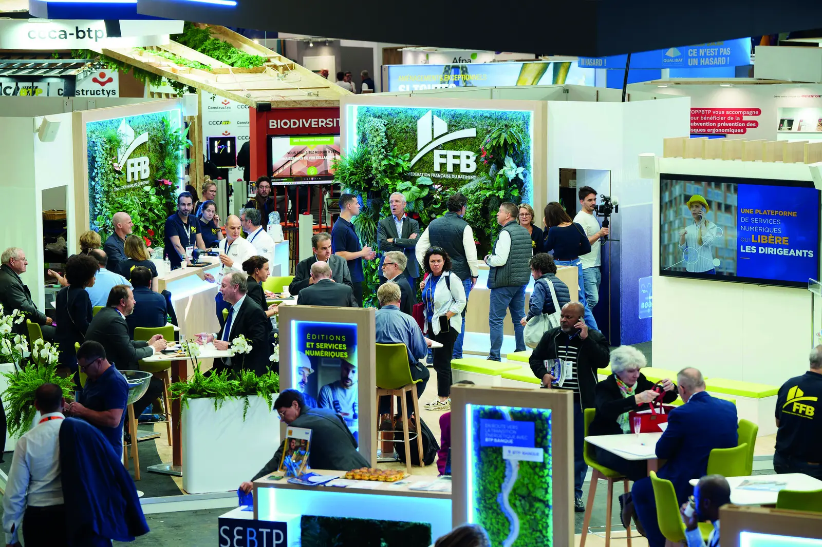Visiteurs en discussion sur un stand du salon
