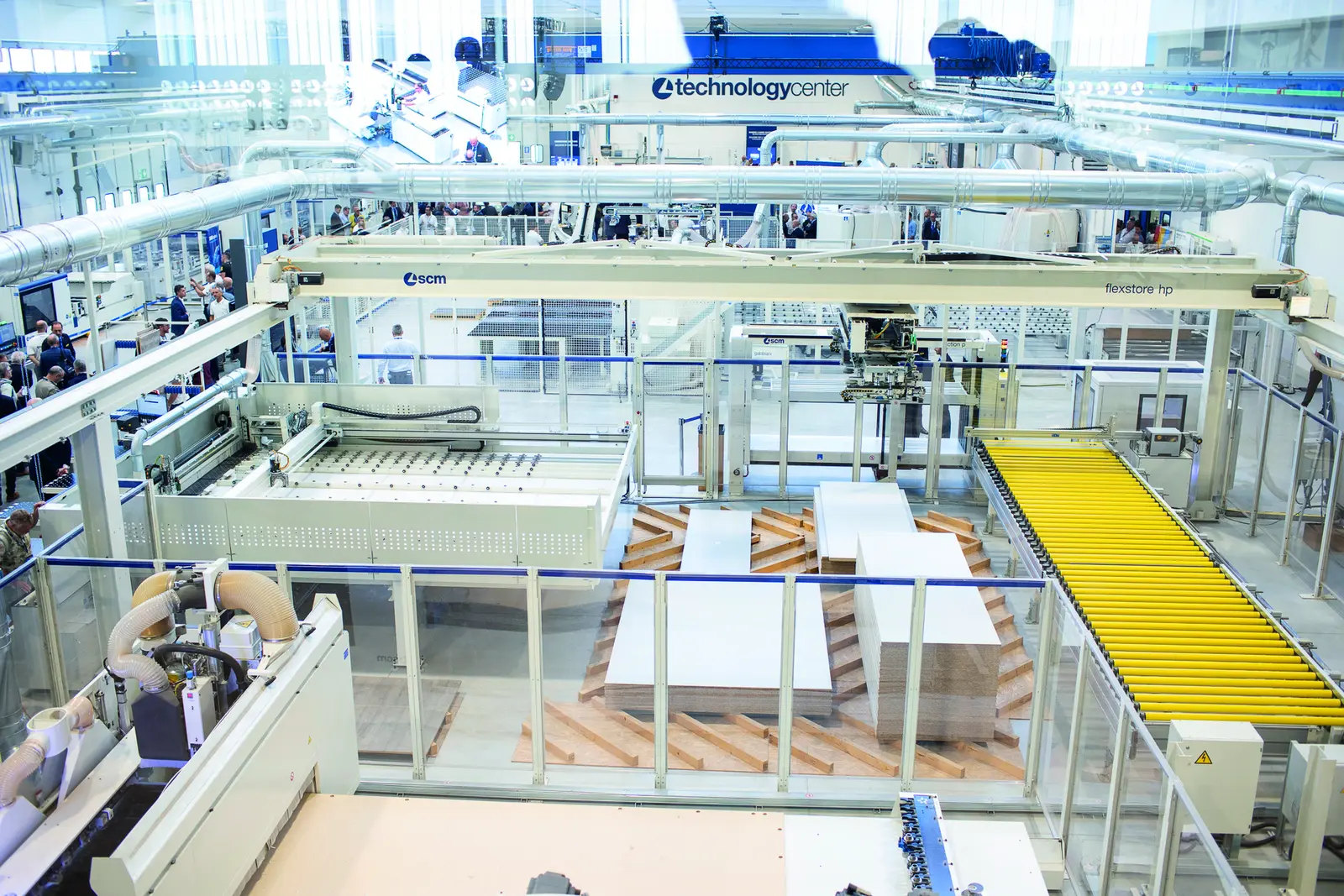 Vue plongeante sur une ligne de machines et un convoyeur &agrave; rouleaux jaunes au Technology Center SCM de Rimini