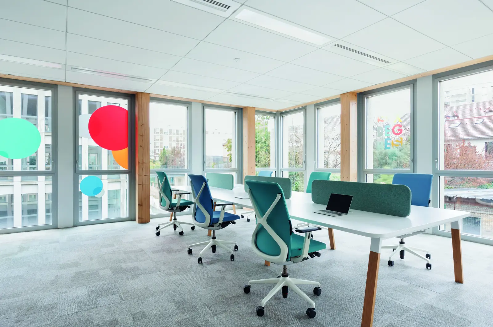 Espace de travail ouvert sous plafond blanc, poteaux en bois
