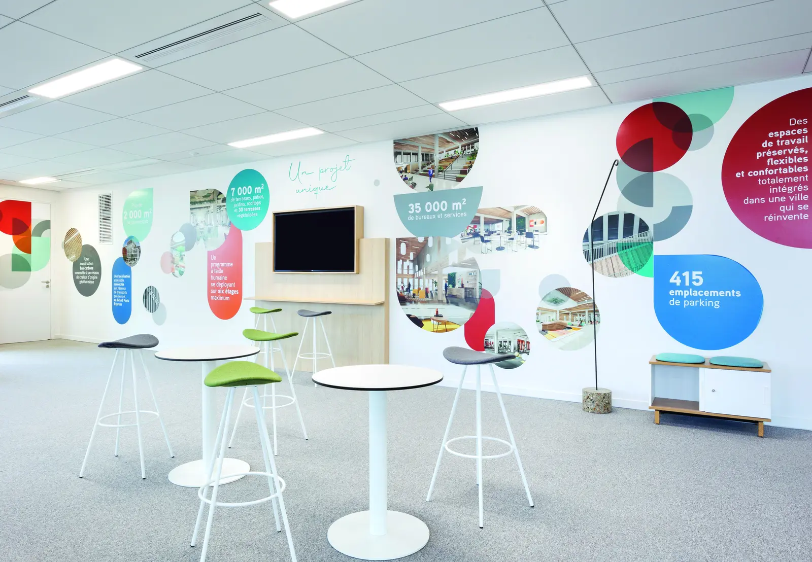 Espace d&eacute;tente avec tables hautes et fresque murale