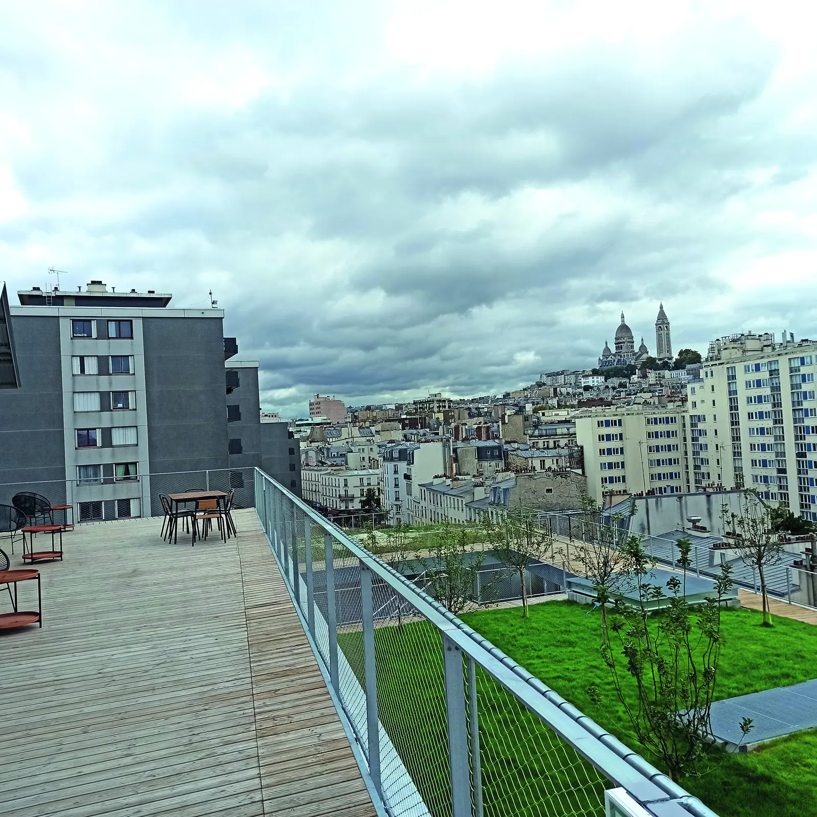 Terrasse en platelage bois et toiture v&eacute;g&eacute;talis&eacute;e avec vue sur les toits de Paris et le Sacr&eacute;-C&oelig;ur