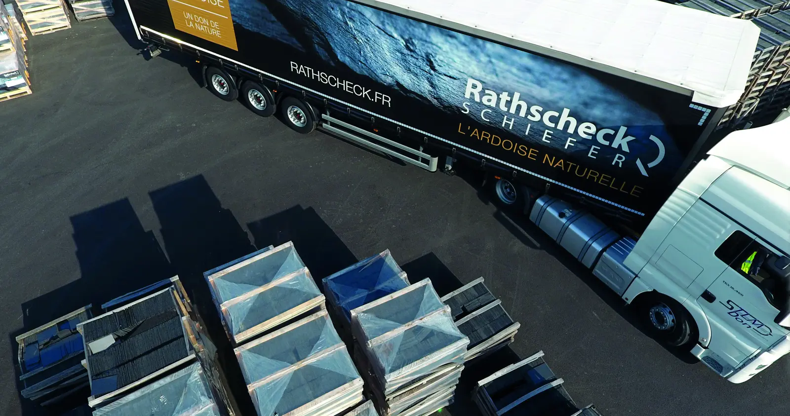 Camion Rathscheck à côté de palettes d’ardoises
