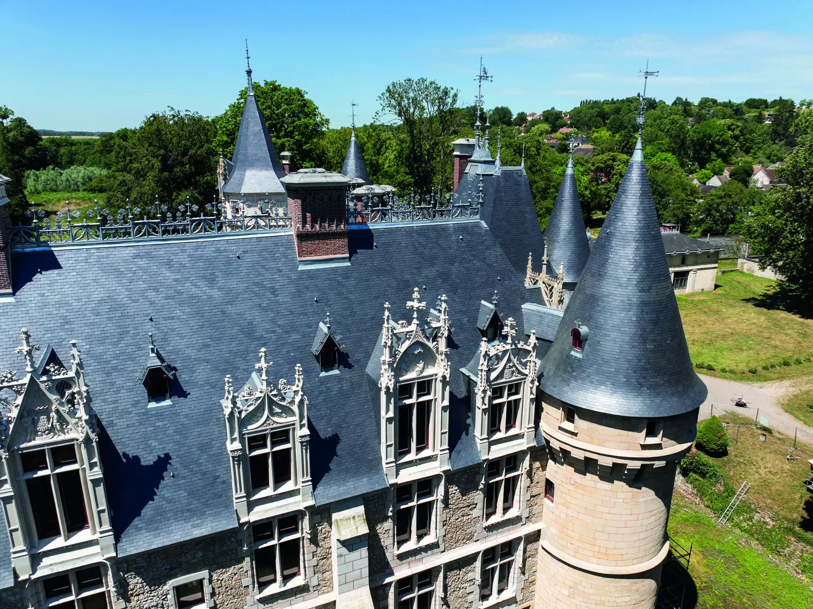 Façade et lucarnes néogothiques sous la toiture en ardoise
