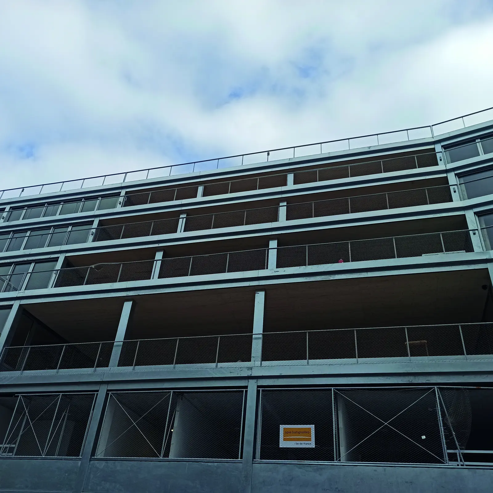 Fa&ccedil;ade en bardage acier galvanis&eacute; du b&acirc;timent en cours d&rsquo;ach&egrave;vement, vue en contre-plong&eacute;e