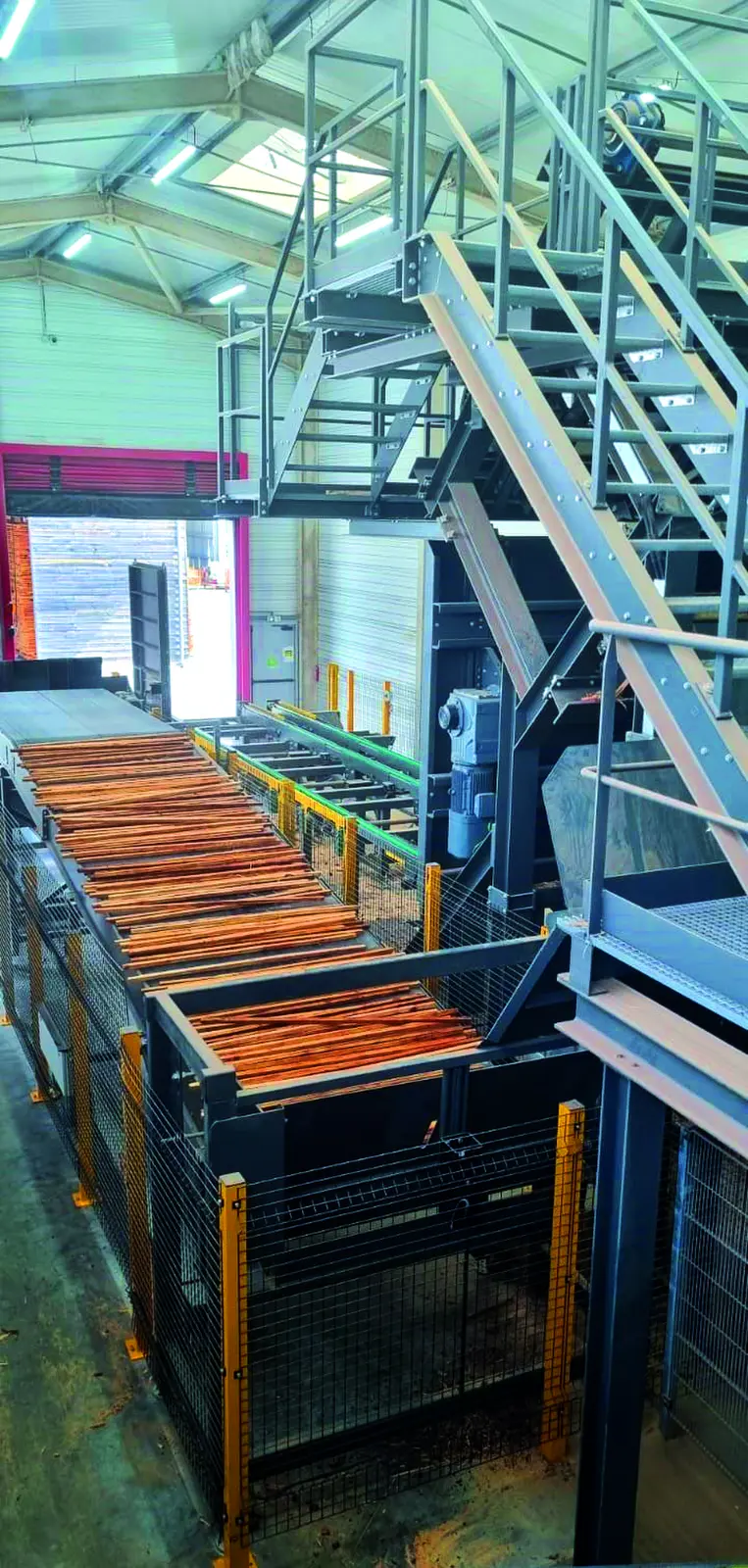 D&eacute;pileur avec des planches de pin sur convoyeur et escalier m&eacute;tallique