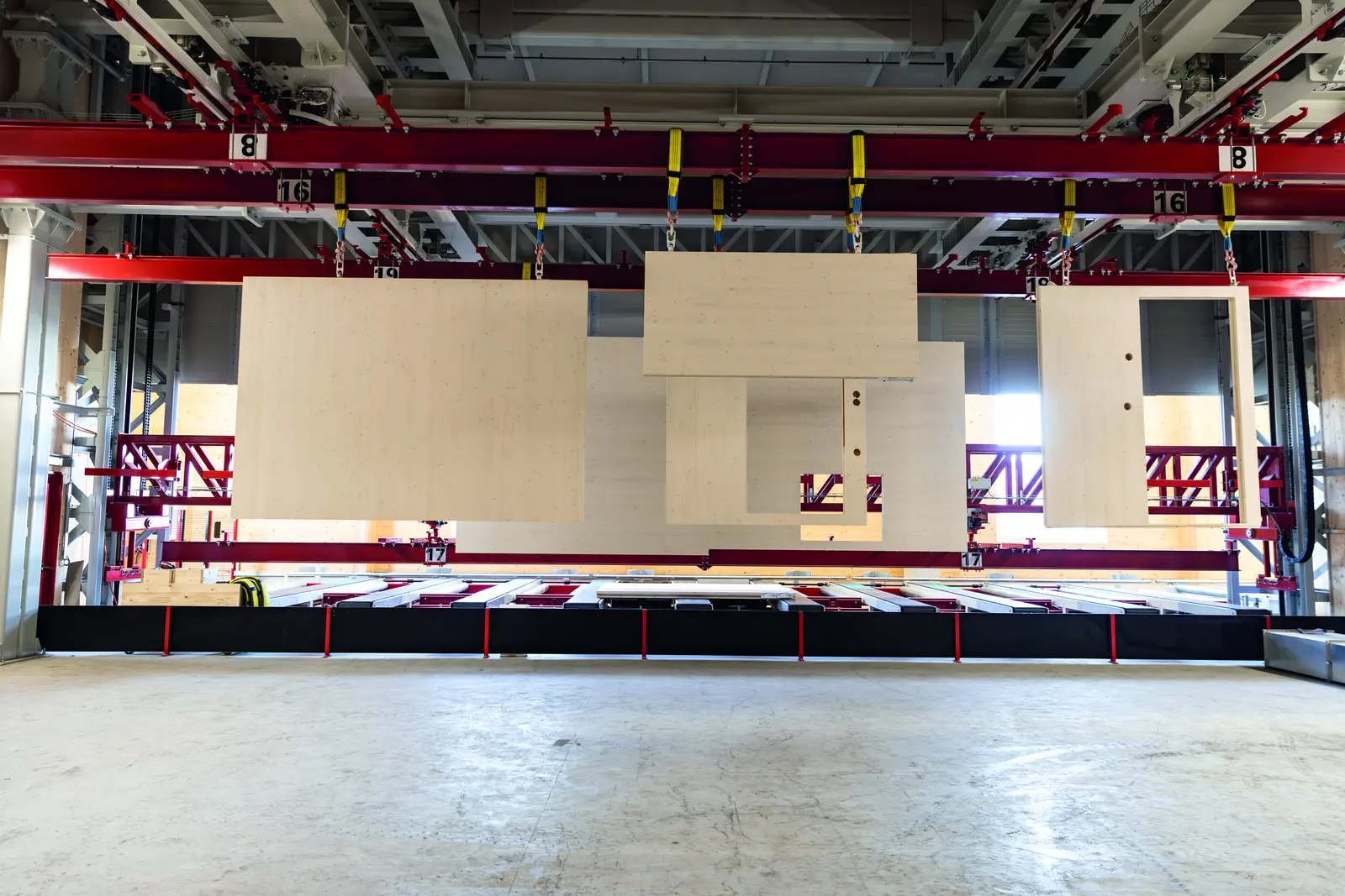 Hall d&rsquo;usine avec des panneaux CLT manutentionn&eacute;s par un pont roulant rouge