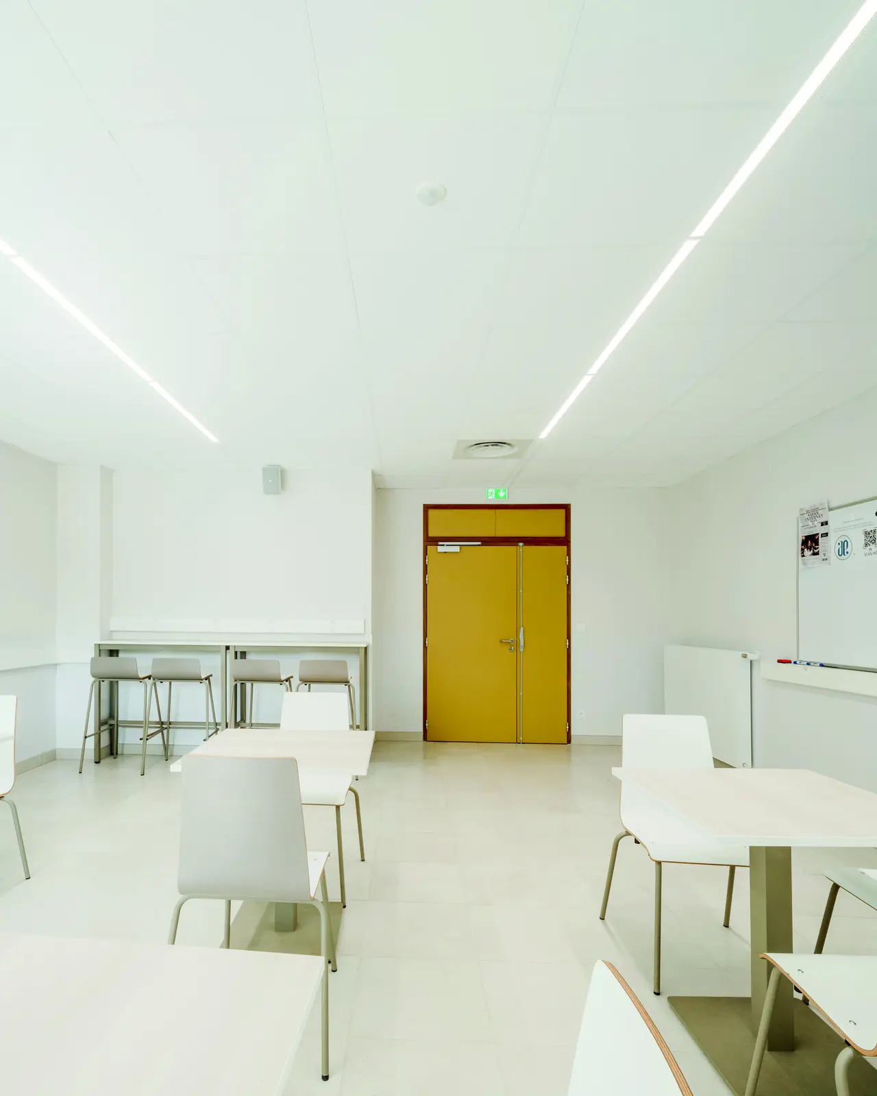 Salle avec tables et chaises sous plafond blanc
