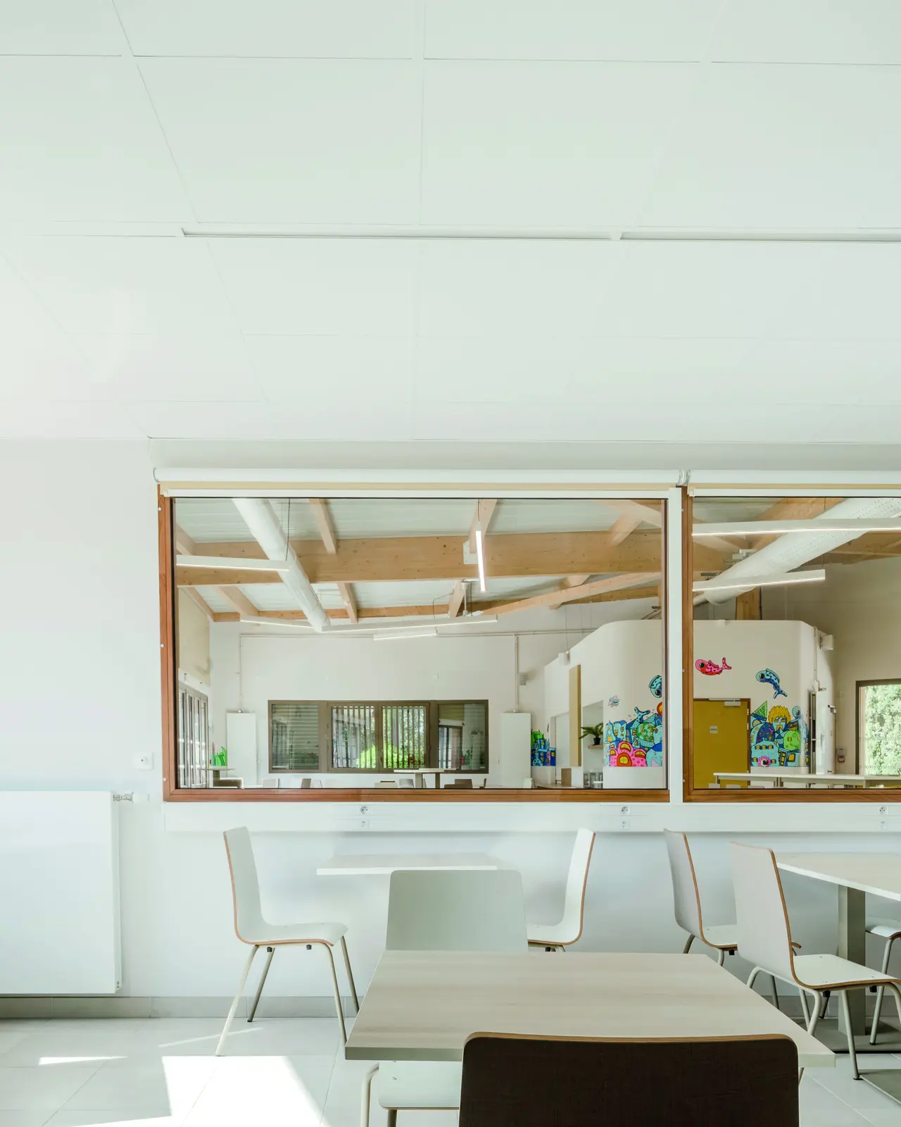 Salle avec ouverture vitr&eacute;e sur un espace voisin