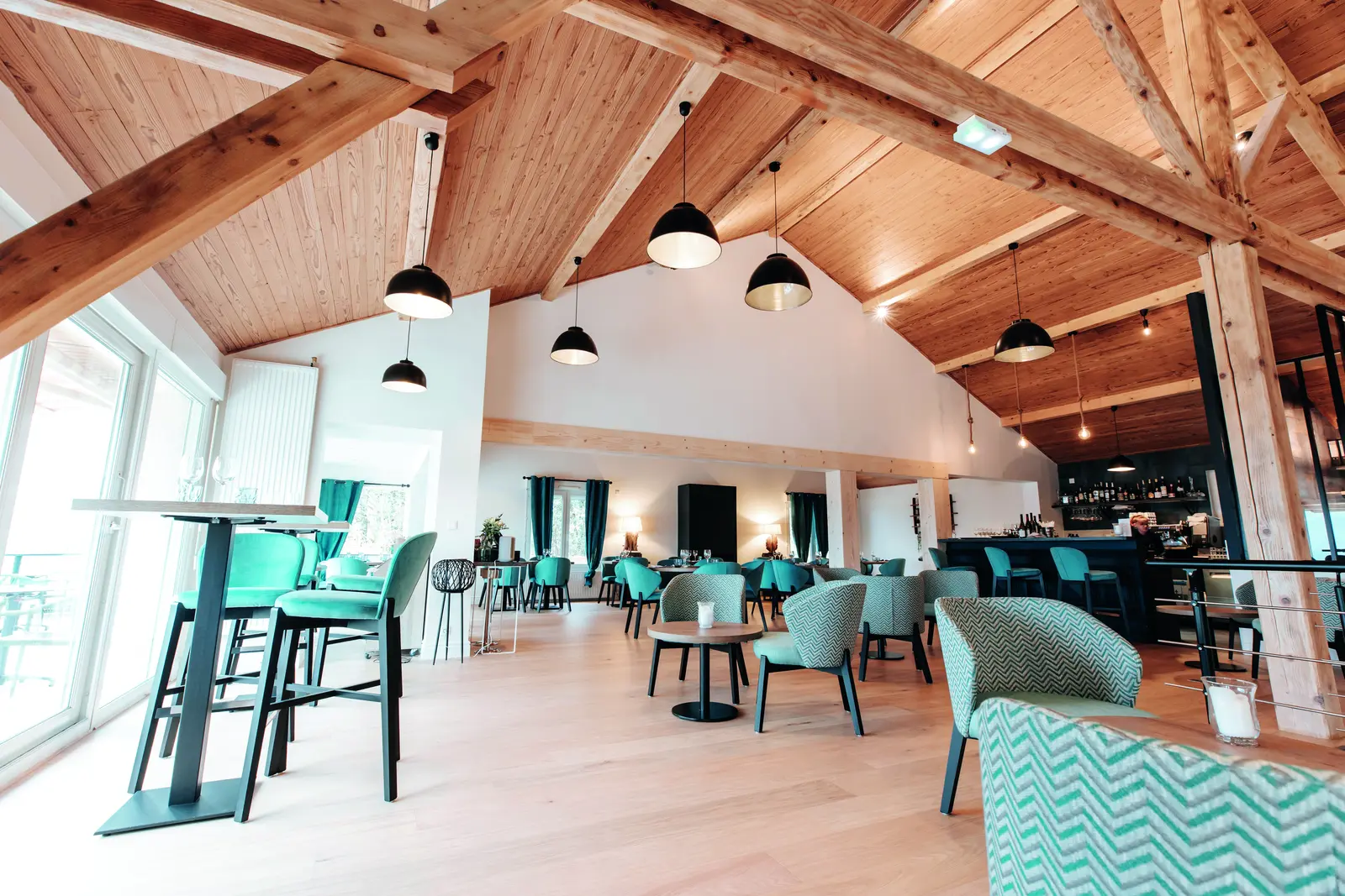 Vue d&rsquo;ensemble de la salle de restauration des Loges du L&eacute;man sous charpente bois apparente