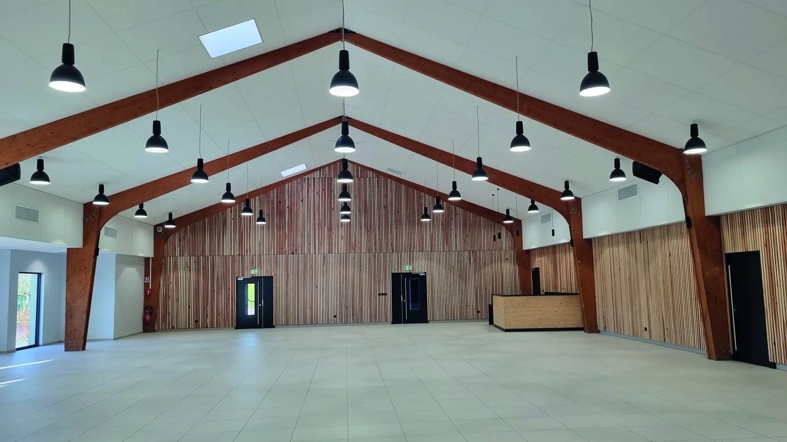 Salle des f&ecirc;tes de Bois-de-Haye r&eacute;nov&eacute;e : portiques en lamell&eacute;-coll&eacute;, parements muraux en bois &agrave; claire-voie et suspensions