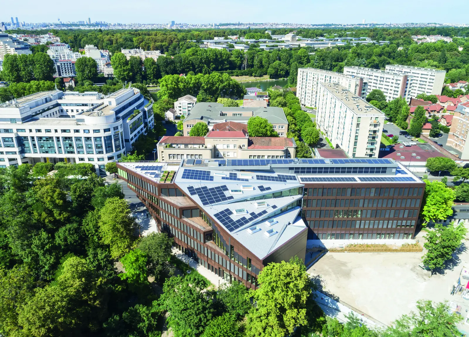 Vue a&eacute;rienne du b&acirc;timent et de sa toiture dans son environnement urbain et arbor&eacute;