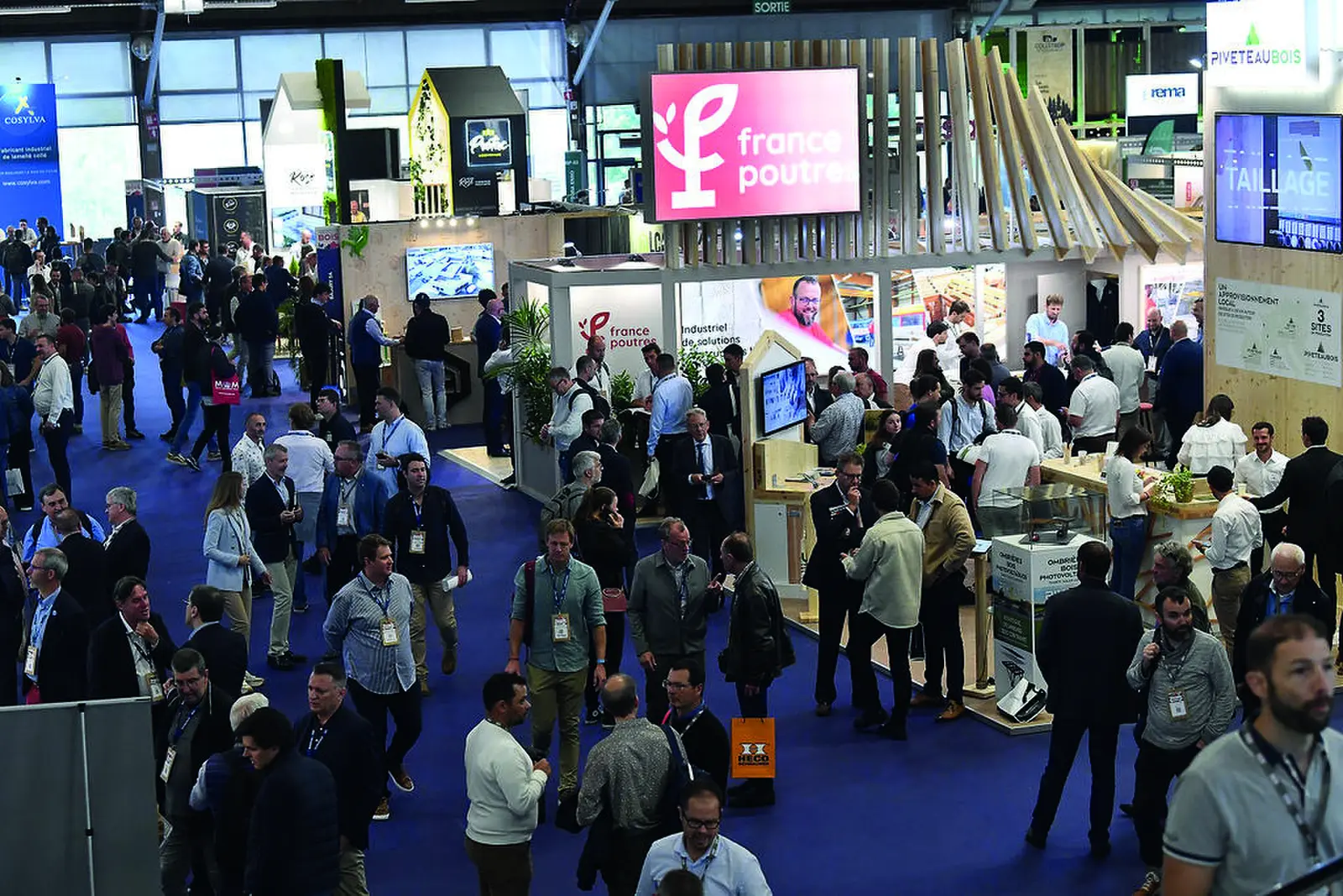 Visiteurs devant les stands du salon